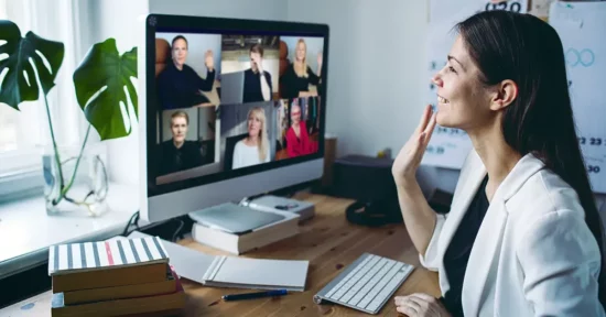 girl waving hand to colleagues over video call